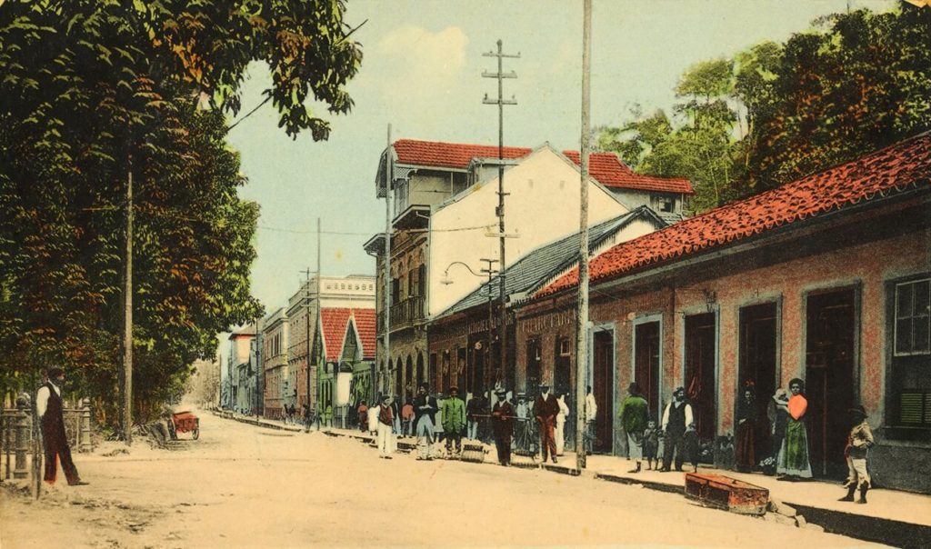 Cartão-postal mostrando trecho da avenida Quinze de Novembro, atual rua do Imperador, onde se veem transeuntes e o comércio à direita.