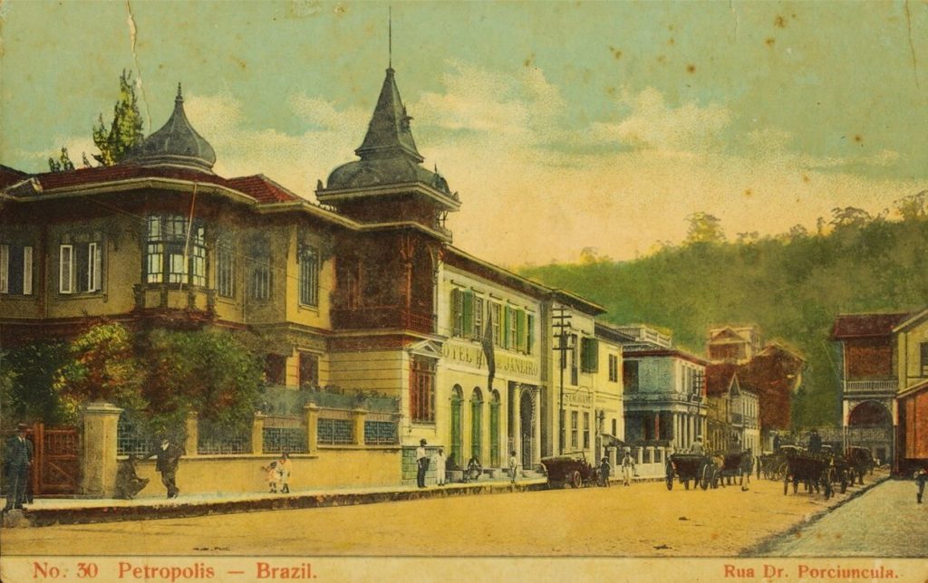 Cartão-postal impresso colorido mostrando a Rua Doutor Porciúncula. À direita, parte da estação Leopoldina, atual terminal rodoviário de integração Imperatriz Leopoldina, e, à esquerda, alguns hotéis, entre eles o Hotel Rio de Janeiro.