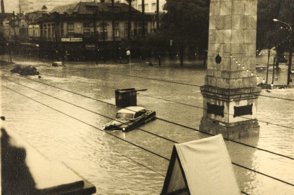Enchente que atingiu a avenida Quinze de Novembro e a praça Dom Pedro II no dia 22 de dezembro de 1925. Veem-se um automóvel e o obelisco e, ao fundo, a Casa d'Angelo.