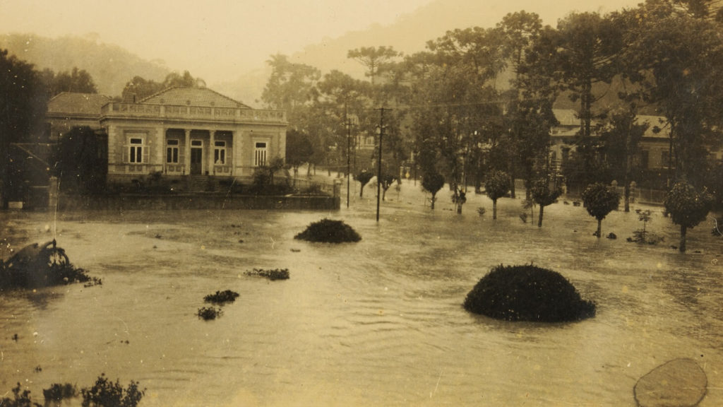 Inundação na praça Visconde de Mauá e na rua da Imperatriz, no dia 20 de março de 1930. Vê-se, ao fundo, mais à esquerda, o prédio onde funcionava a antiga biblioteca municipal. No local, hoje está localizado o Centro de Cultura Raul de Leoni.